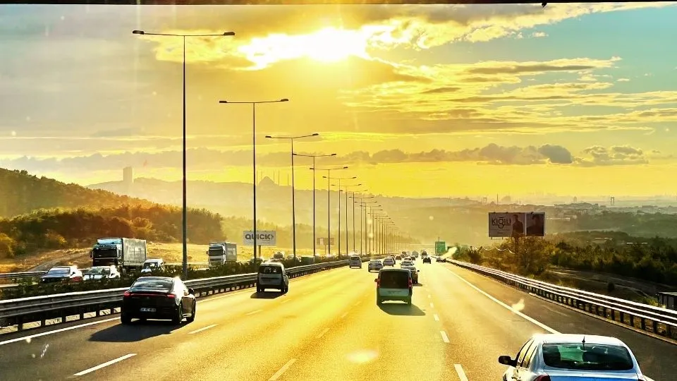 Autopista de entrada a Estambul al atardecer con el perfil de la ciudad y los minaretes en el horizonte