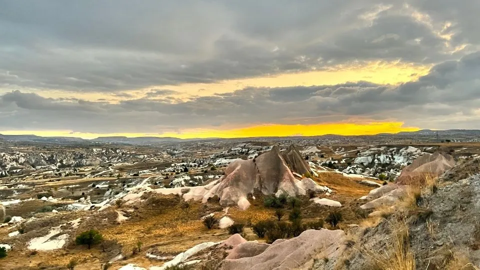 Rose Valley in Cappadocia at sunset, with the rock formations under a cloudy sky