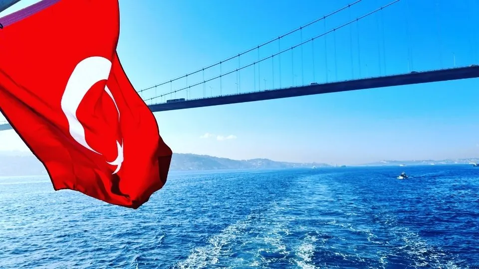 Turkish flag at the stern of a boat under the Bosphorus Bridge, Istanbul