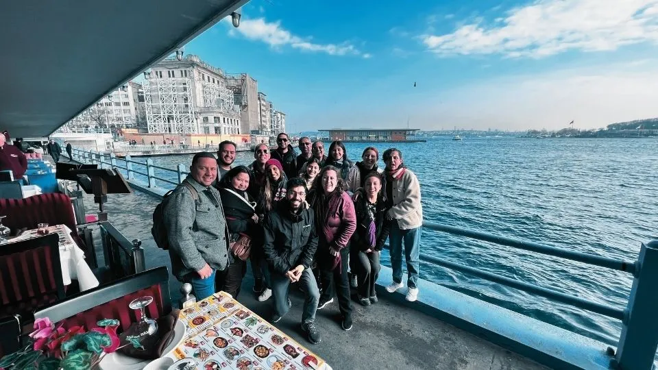 Group of travellers with their guide under the Galata Bridge, with the Golden Horn behind