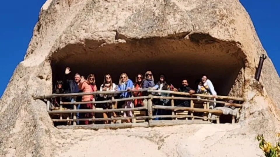 Small party of travellers looking out from a carved fairy chimney in Cappadocia